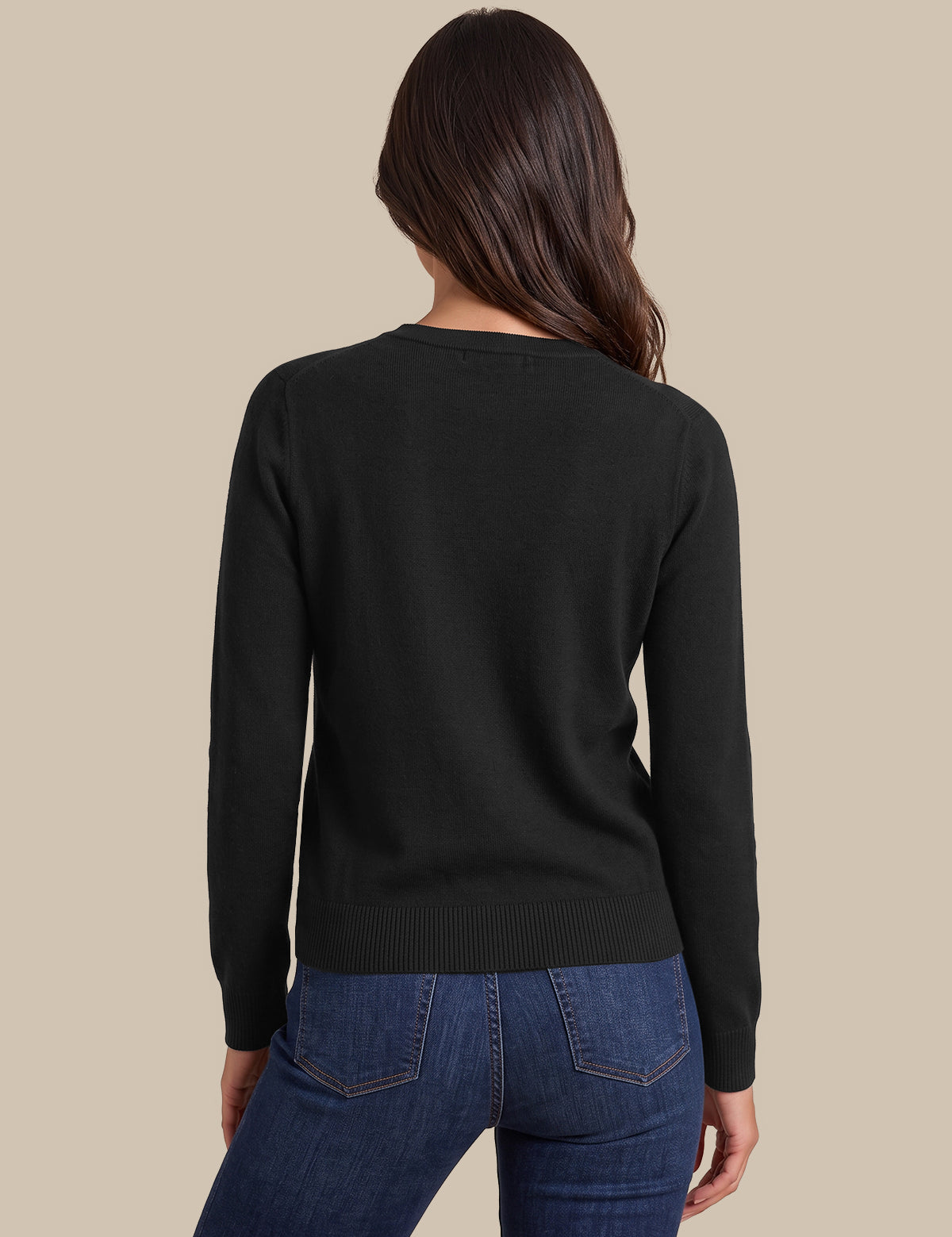 A woman shown from the back wearing a black long-sleeve knit sweater and blue jeans against a plain beige studio background.