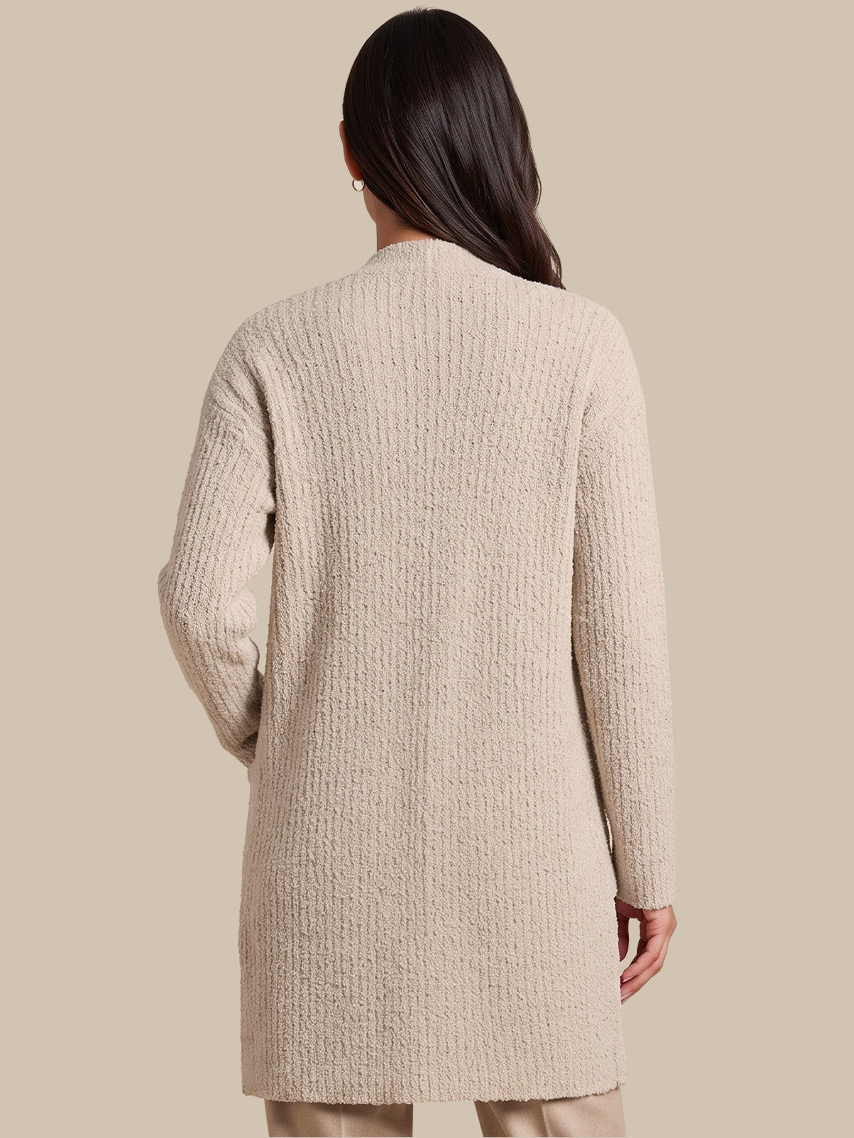 A woman shown from the back wearing a textured, long-sleeve knit cardigan in a light beige color, set against a solid beige studio background.