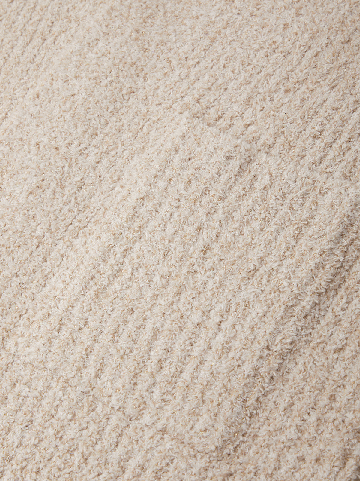 A close-up texture shot of a plush, looped pile fabric in a warm cream or light beige color.