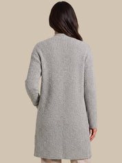 A woman shown from the back wearing a light gray textured knit cardigan sweater, set against a solid beige studio background.