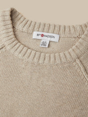 Close-up of a beige knit sweater with a ribbed crew neck and a visible neck label reading 89th & Madison.