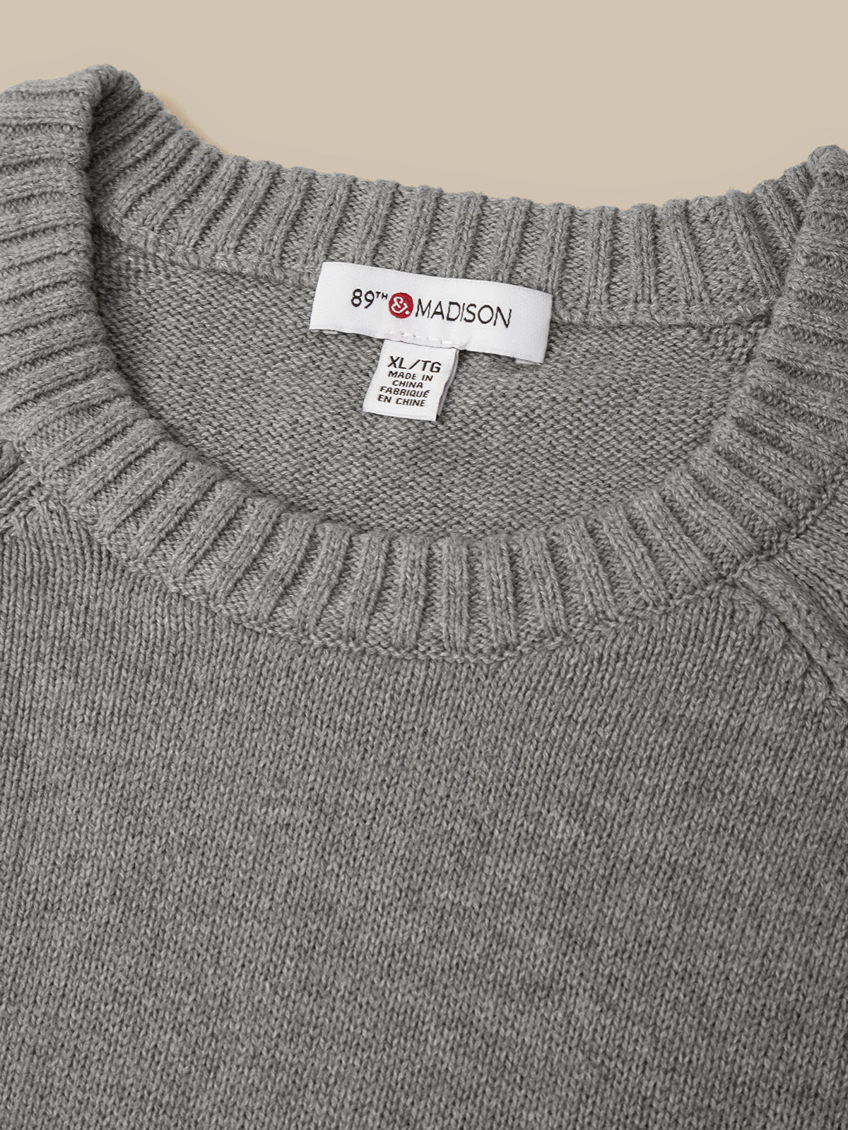 Close-up of a gray ribbed knit sweater neck with a visible white 89th & Madison brand label.