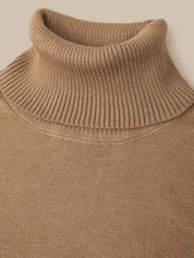 Close-up of a ribbed knit turtleneck sweater in a warm camel brown color, showing the detailed knit texture and collar.