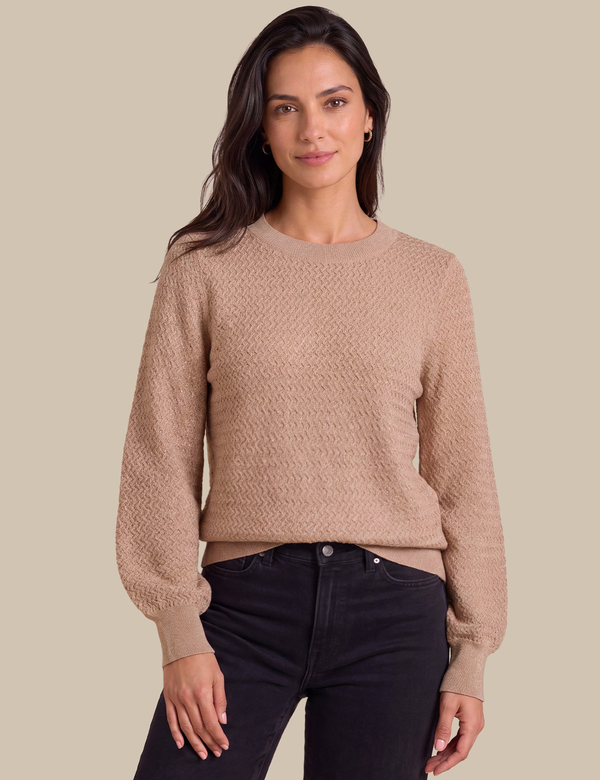 tan color, paired with dark jeans, against a solid beige background.