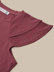 Maroon top with ruffled sleeves on a beige background