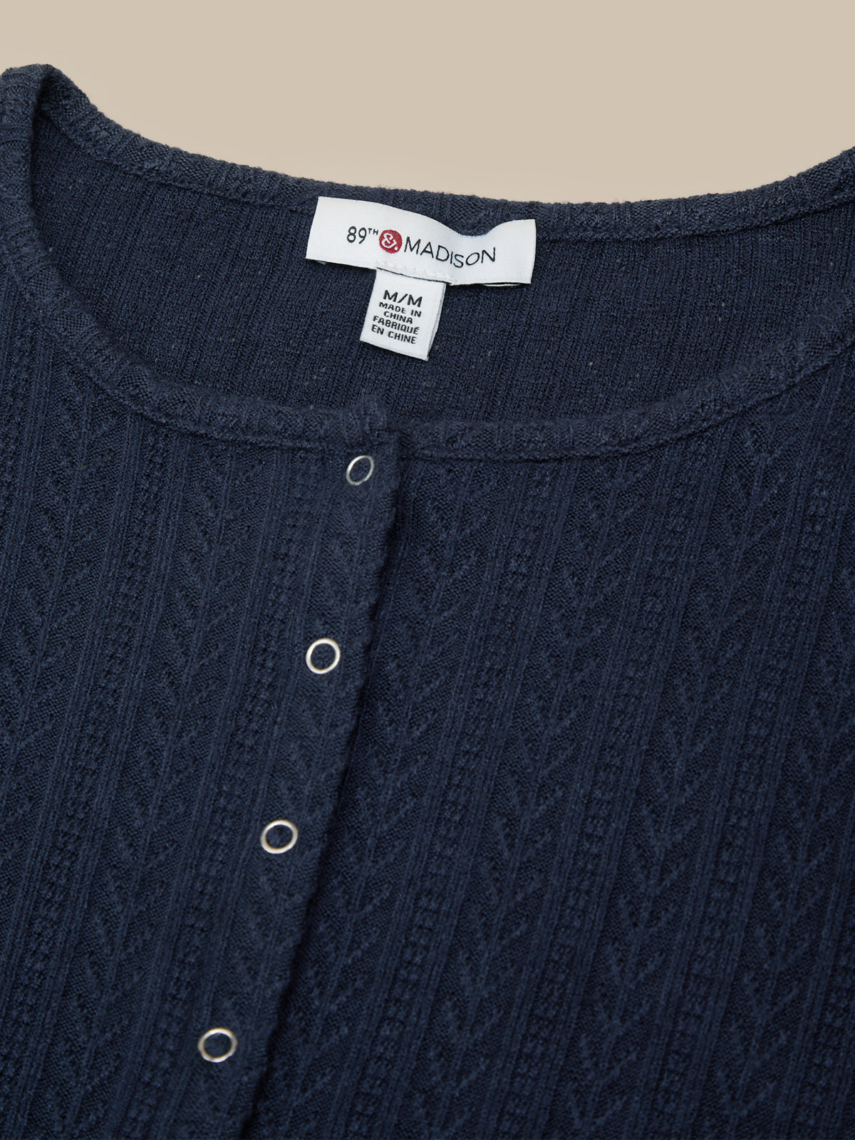 Navy blue garment with a brand label on a beige background