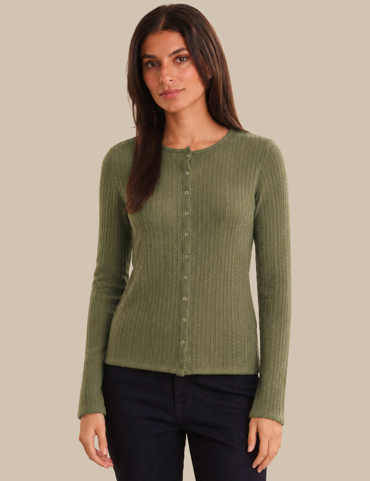 Woman wearing a green ribbed cardigan against a beige background