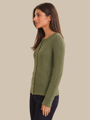 Woman wearing a green cardigan against a beige background