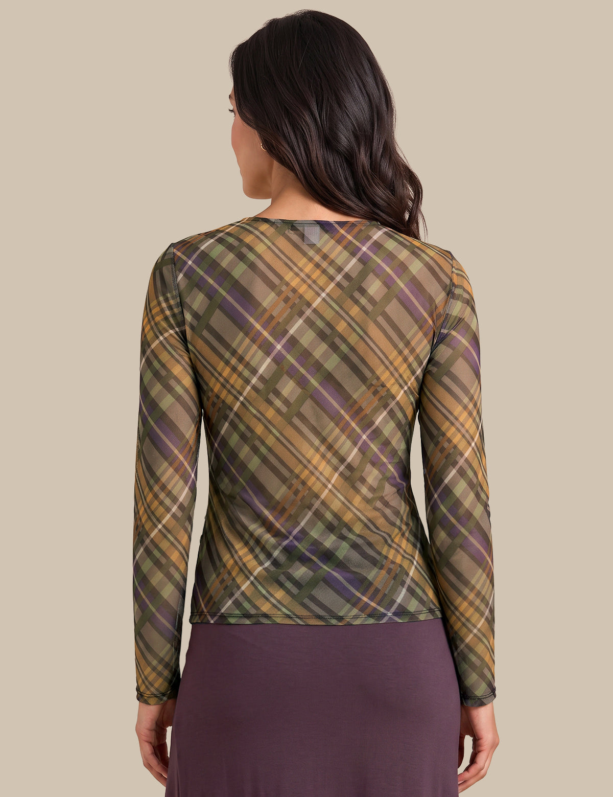 A woman shown from the back wearing a sheer long-sleeve top with a brown, green, and purple plaid pattern, paired with a dark purple skirt, against a solid beige background.