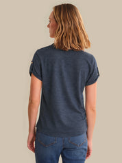 Woman wearing a blue t-shirt and jeans on a beige background
