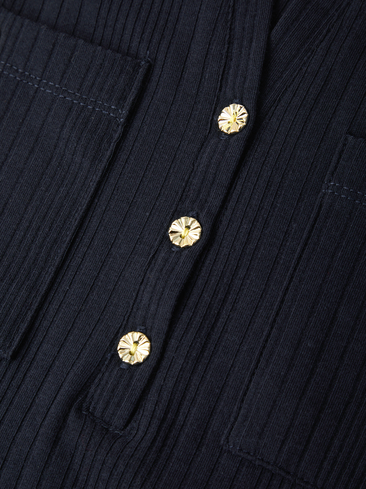 Close-up of a dark navy ribbed fabric garment with three round gold-tone decorative buttons on the front.