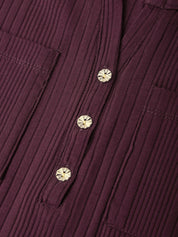 Close-up of a ribbed burgundy corduroy shirt with decorative metallic buttons.