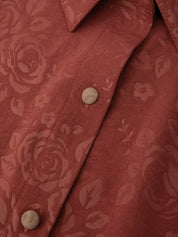 Close-up of a red floral patterned shirt with buttons.