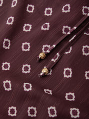 Close-up of a fabric with a pattern and decorative elements on a maroon background