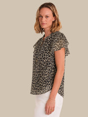 Woman wearing a leopard print blouse against a plain background