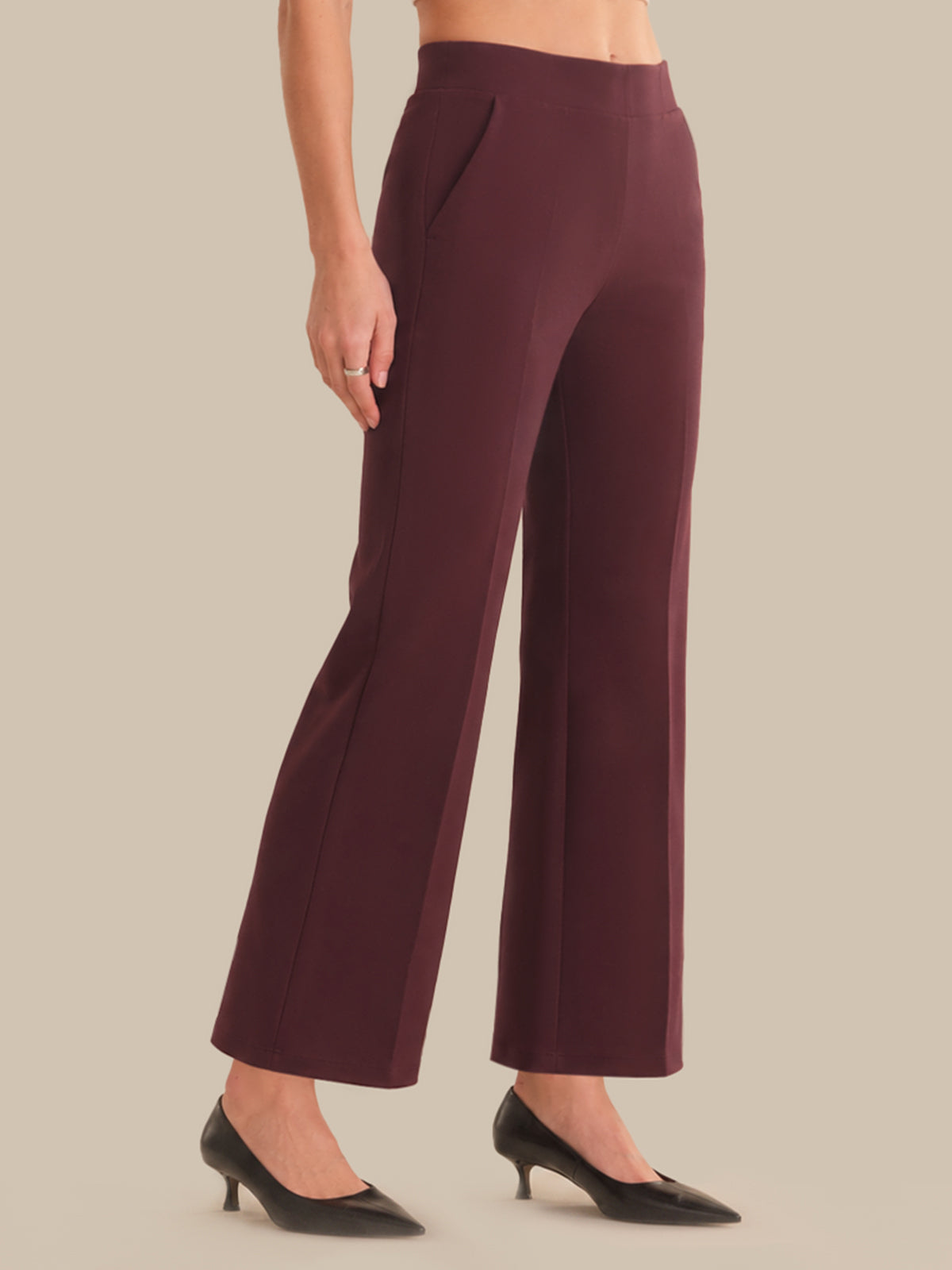 Maroon pants worn by a person on a beige background