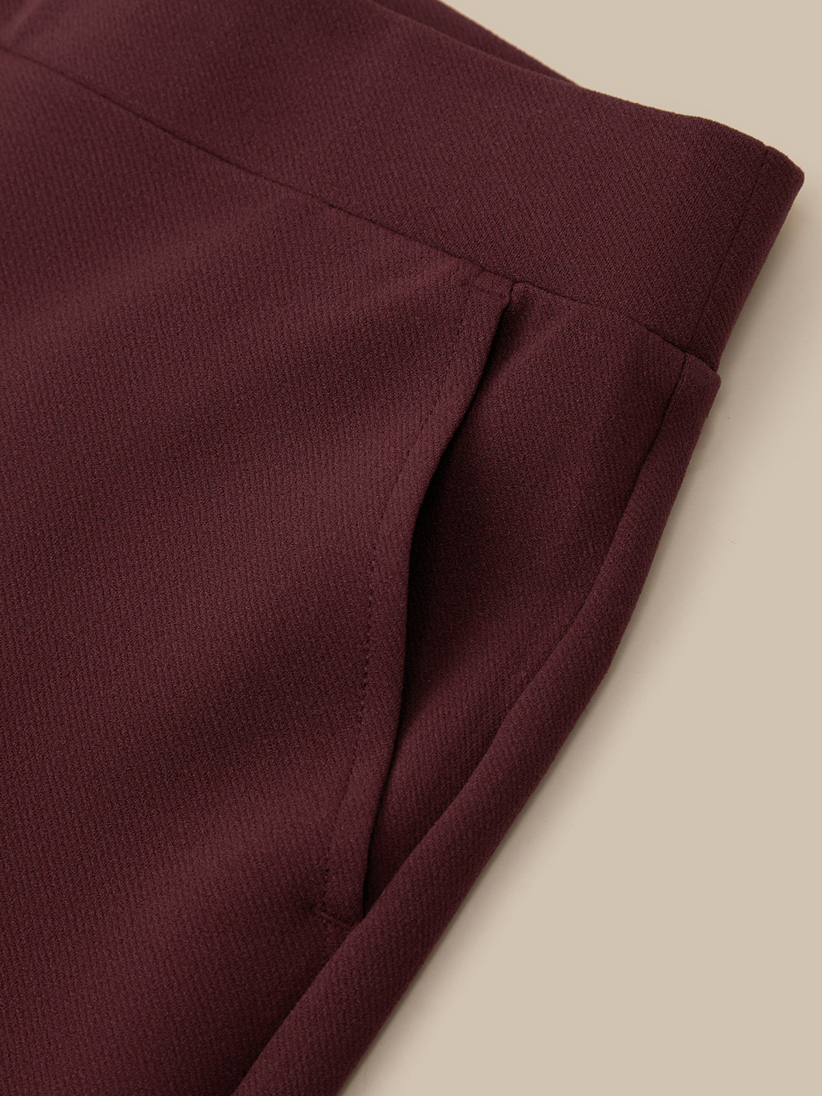 Close-up of a maroon fabric with a beige background