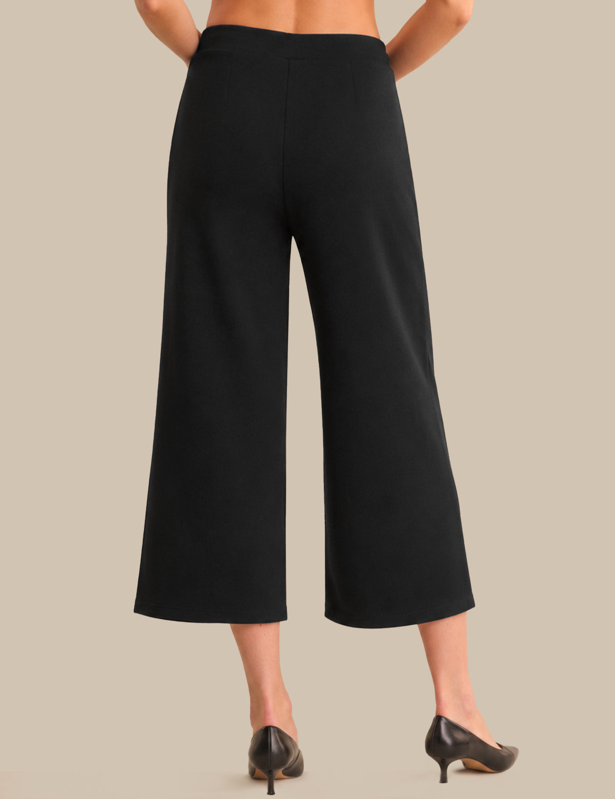 Black wide-leg pants worn by a person on a beige background