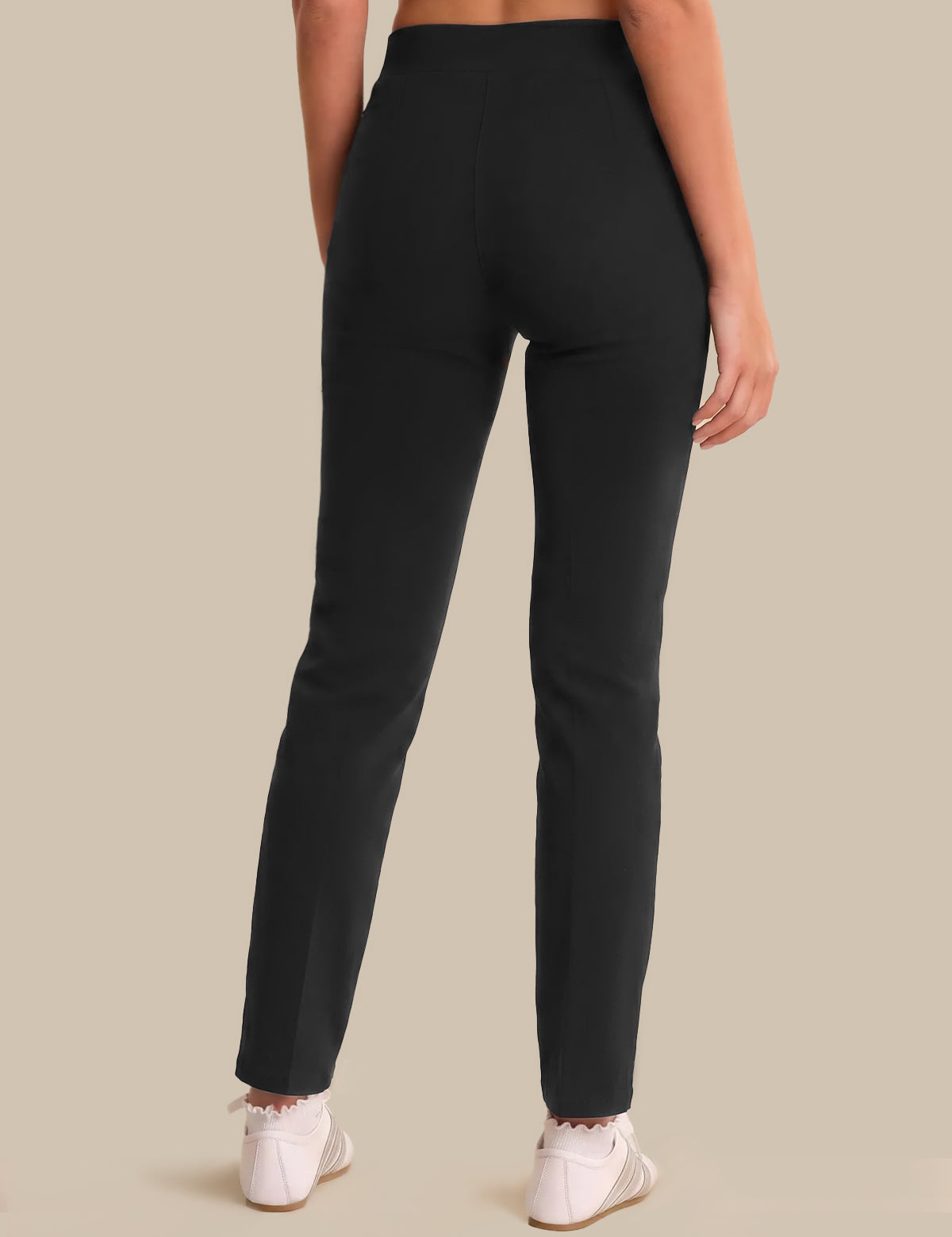 Person wearing black pants on a beige background