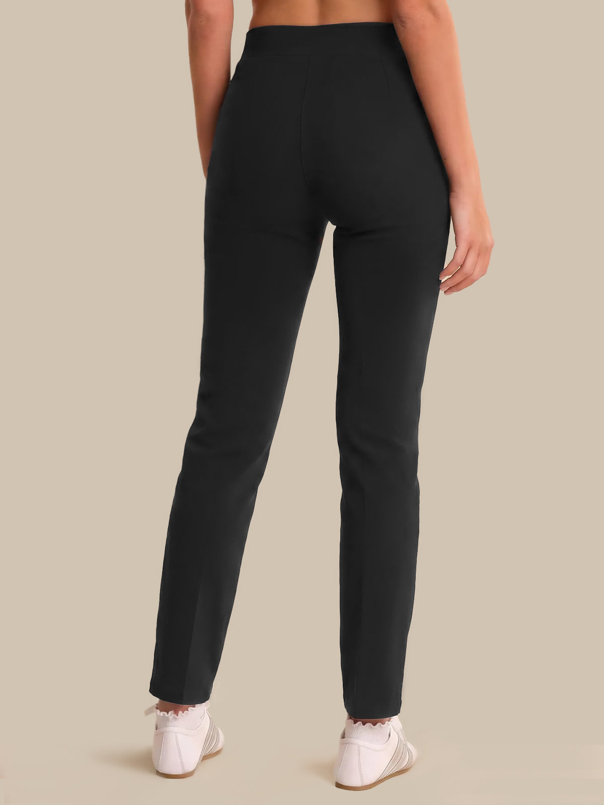 Person wearing black pants on a beige background