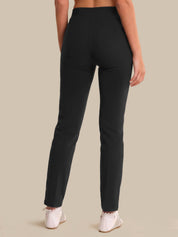 Person wearing black pants on a beige background
