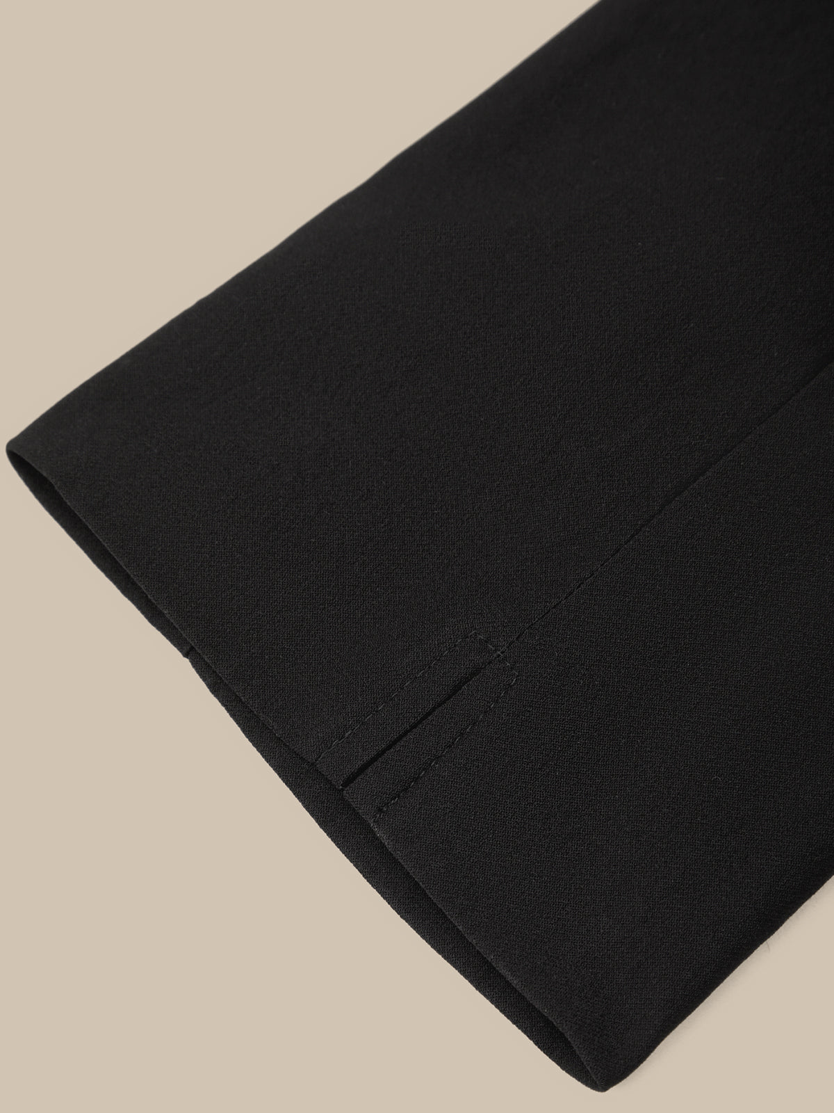 Close-up of a black fabric with a pocket on a beige background