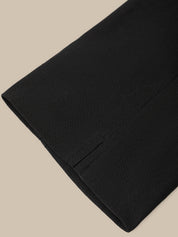 Close-up of a black fabric with a pocket on a beige background