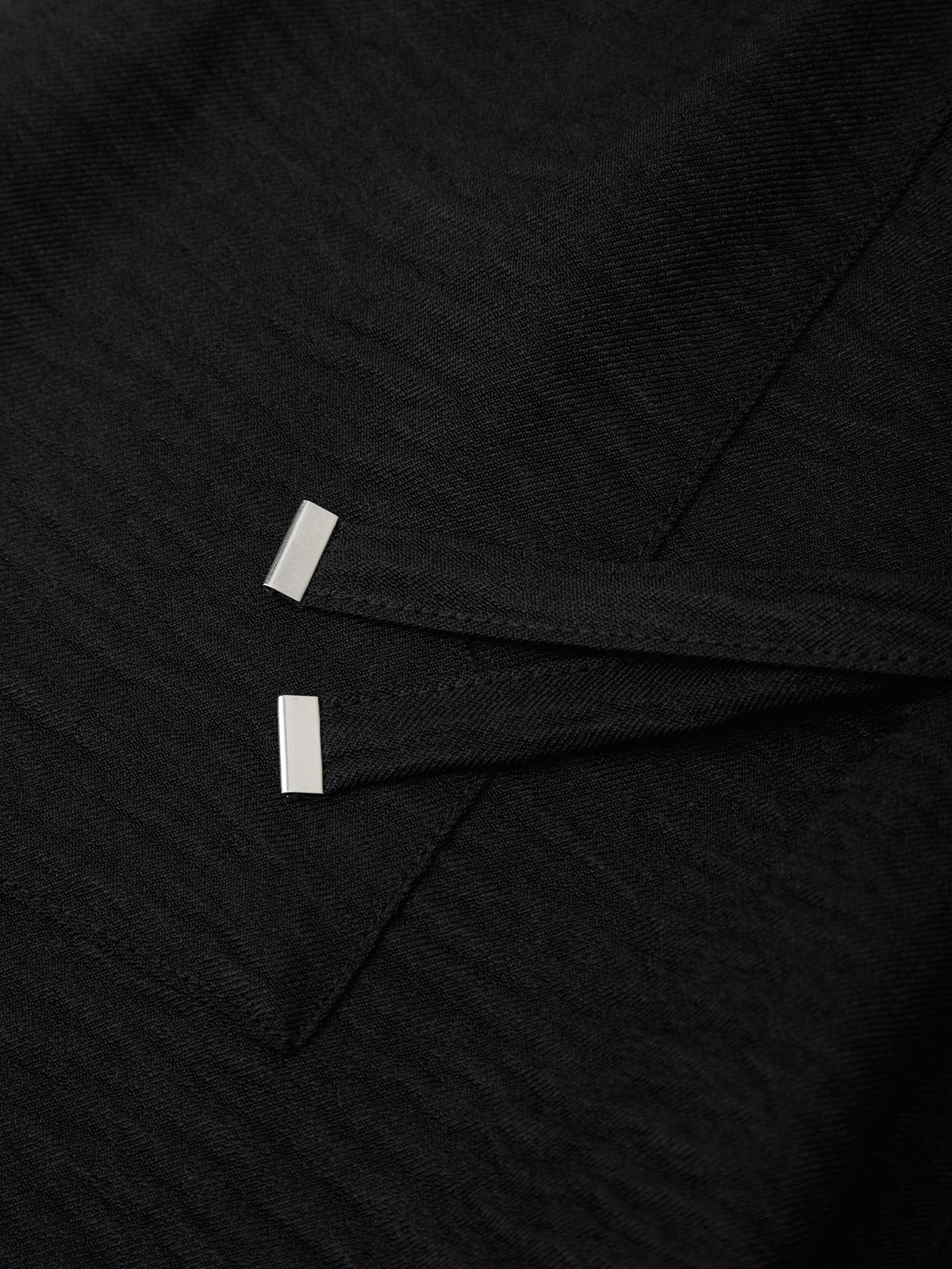 Close-up of black fabric with white stitching details