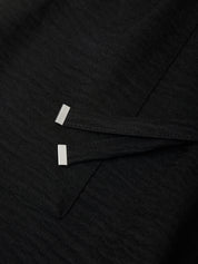 Close-up of black fabric with white stitching details