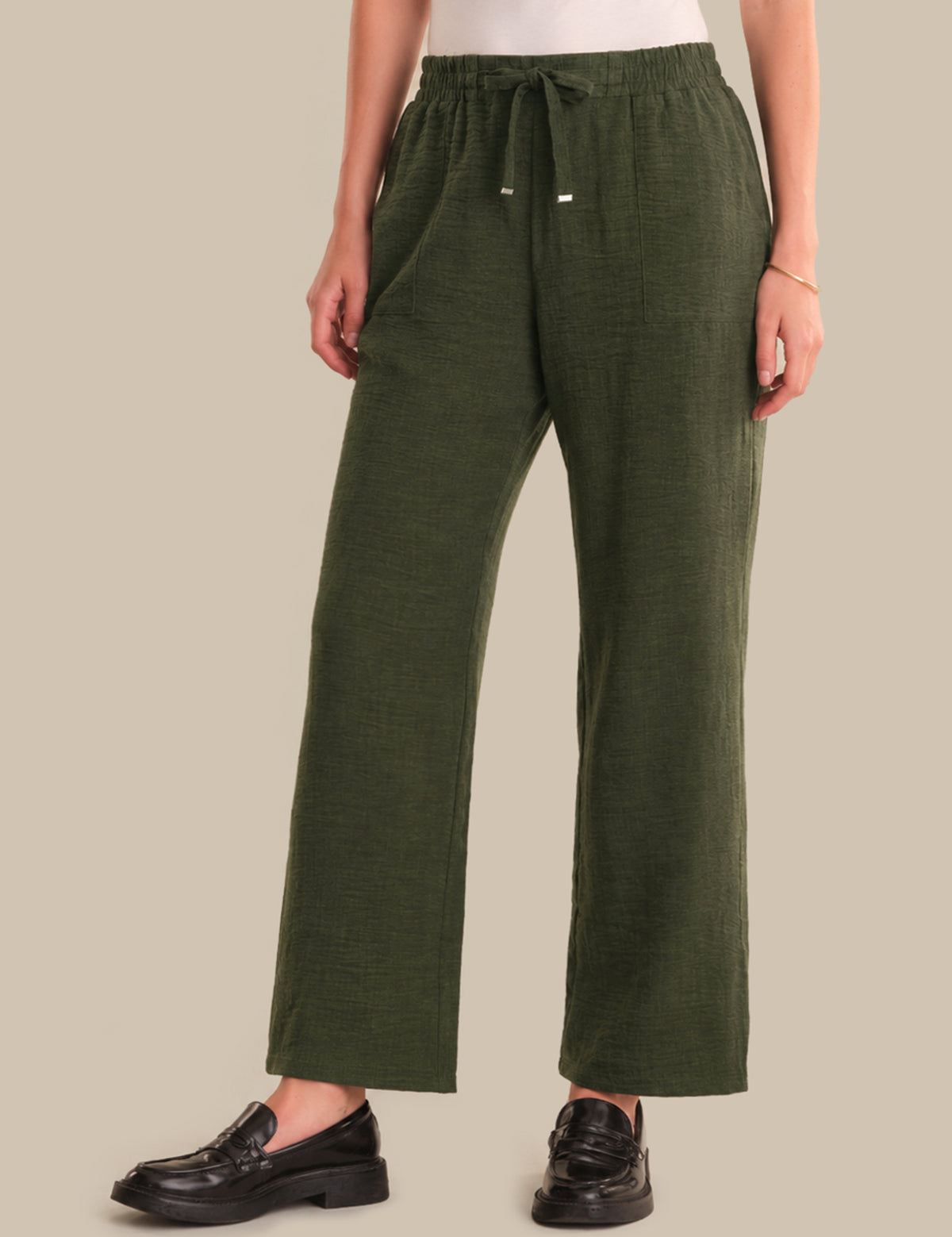 Person wearing green pants on a beige background