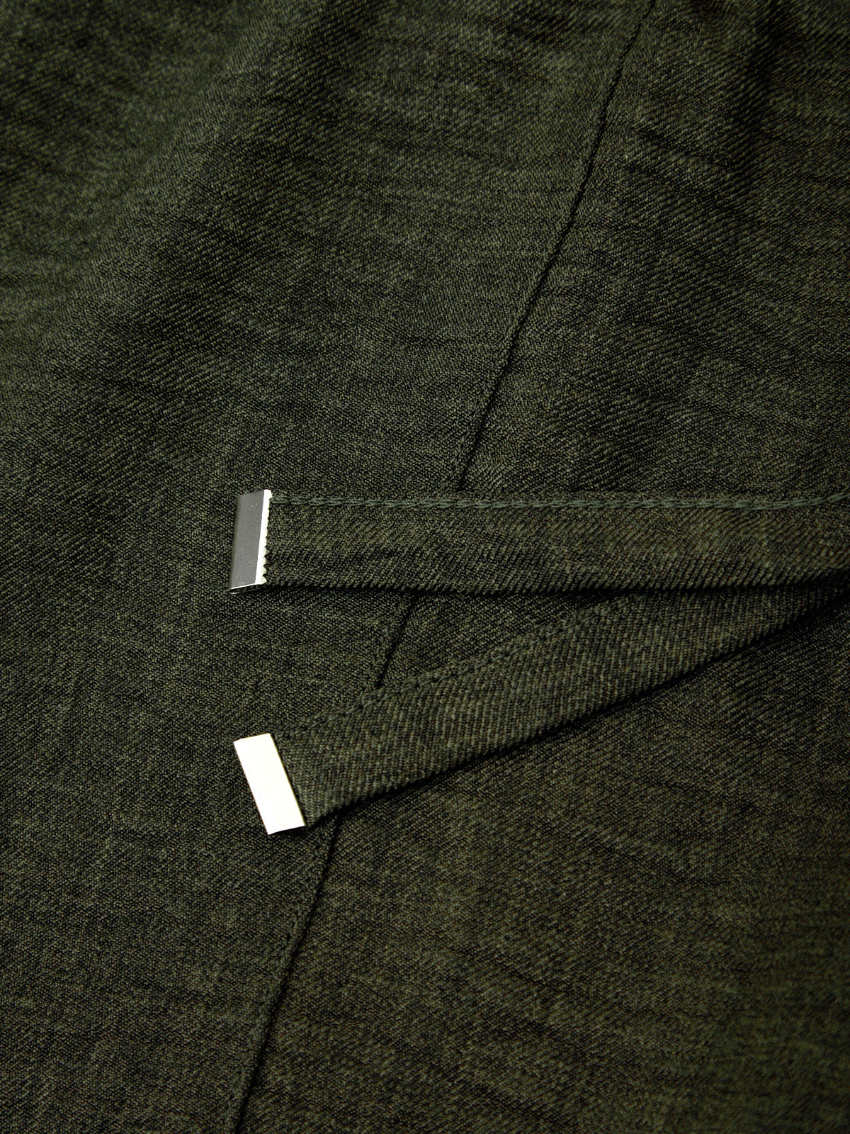 Close-up of a dark green fabric with a subtle pattern