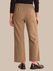 Person wearing brown wide-leg pants on a beige background