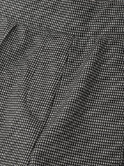 Close-up of a black and white micro-patterned fabric, showing a fine woven texture and soft folds.
