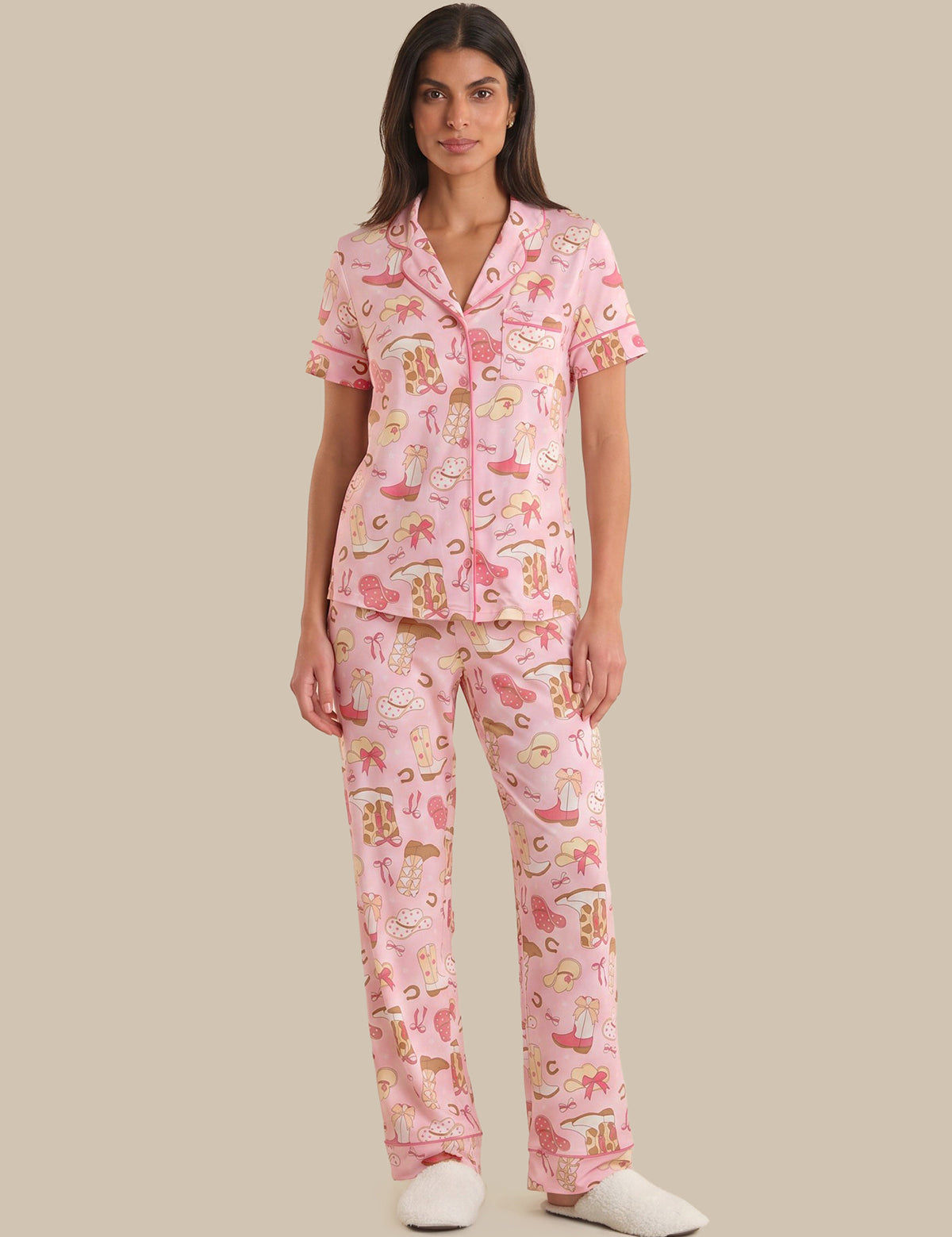 Woman wearing a pink pajama set with cartoon characters on a beige background