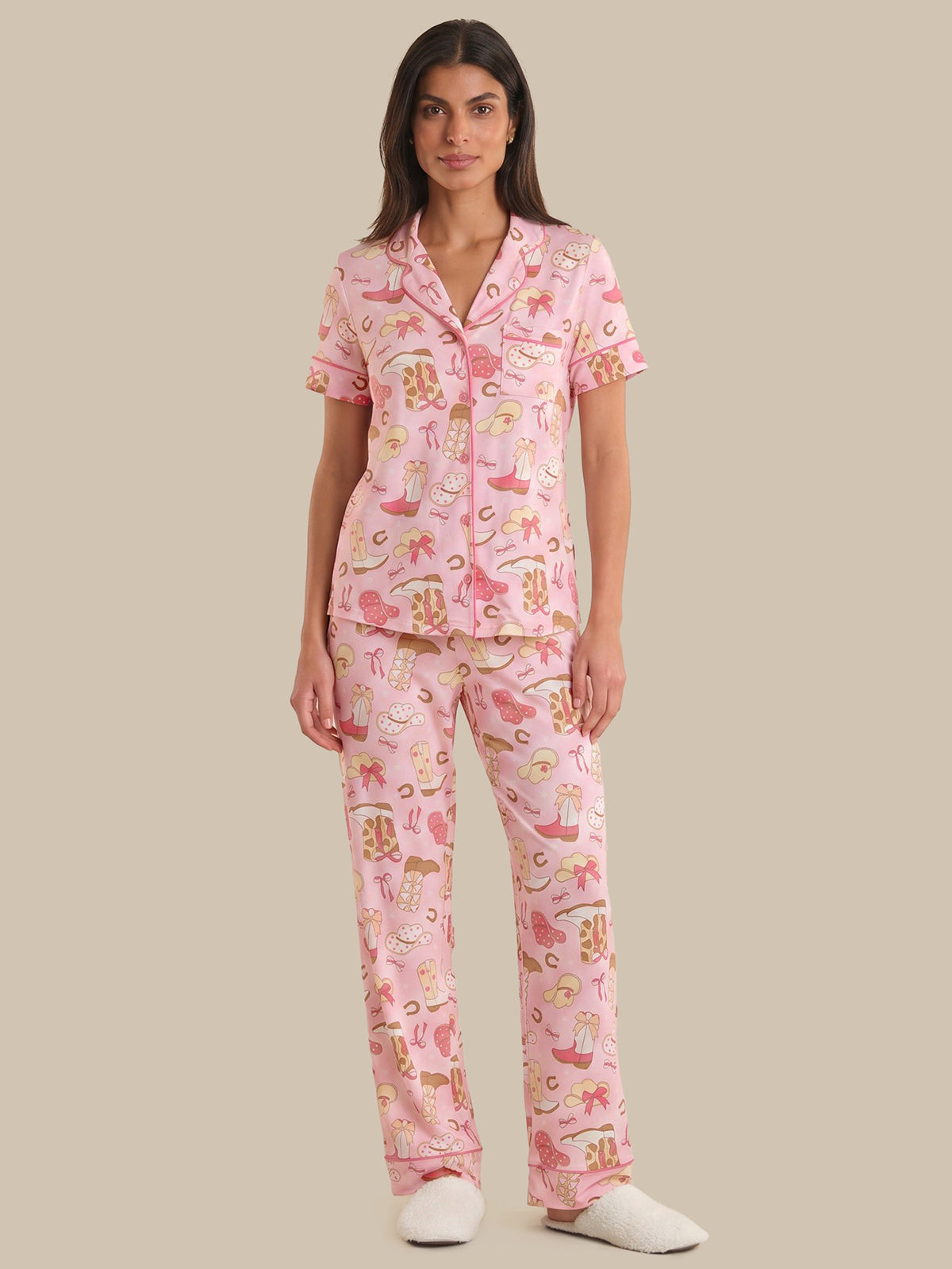 Woman wearing a pink pajama set with cartoon characters on a beige background
