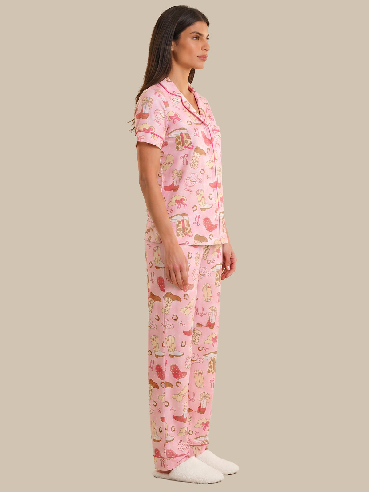 Woman wearing a pink pajama set with animal print on a beige background