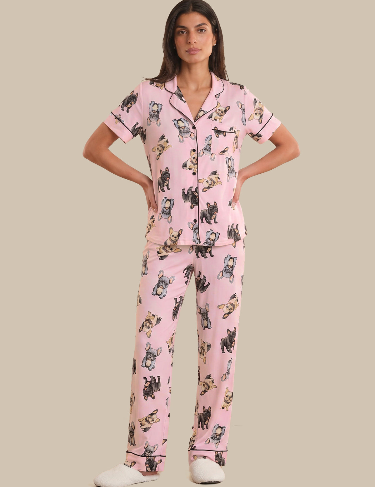 Woman wearing pink pajamas with dog pattern on a beige background