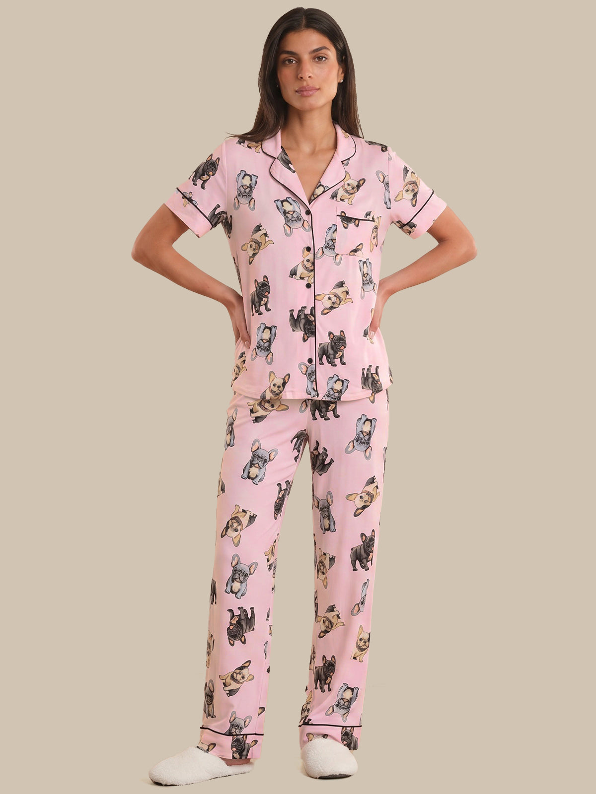 Woman wearing pink pajamas with dog pattern on a beige background
