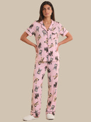 Woman wearing pink pajamas with dog pattern on a beige background