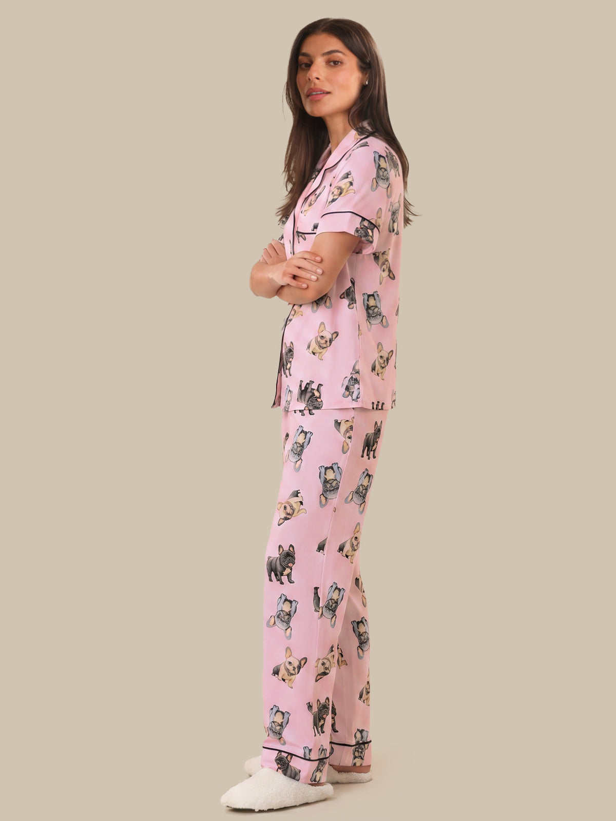 Woman wearing pink pajamas with cat print on a beige background