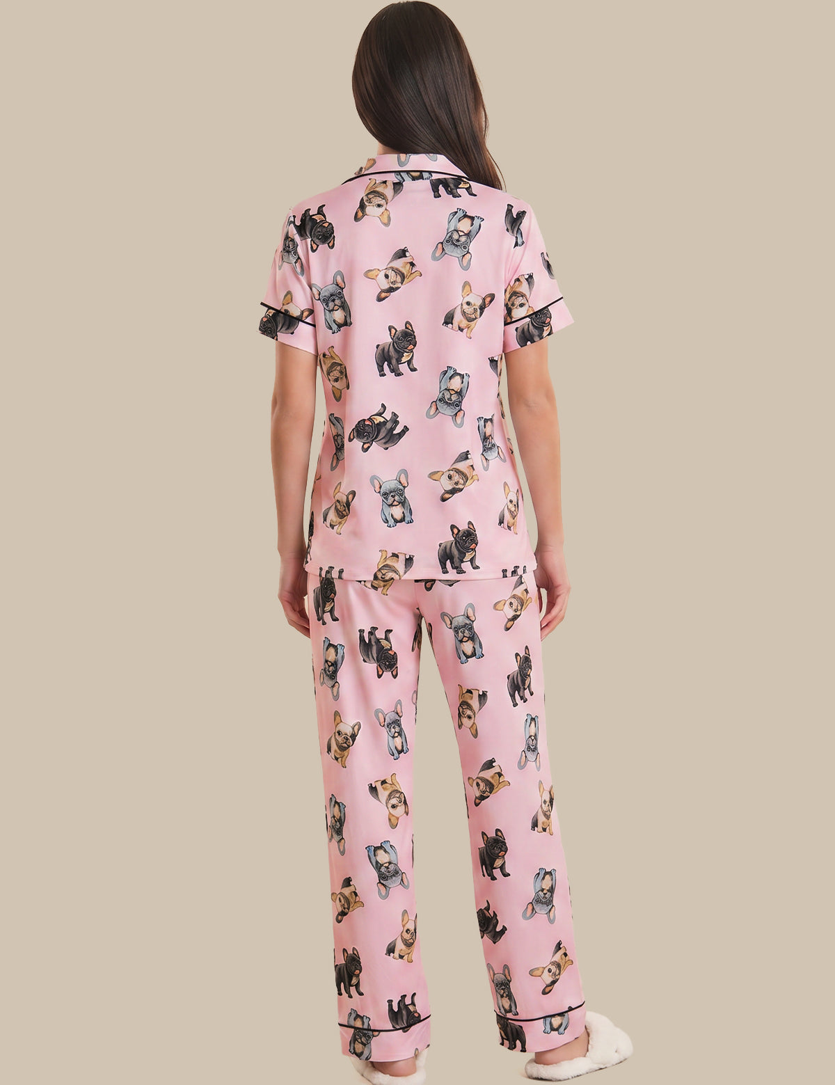 Person wearing pink pajama set with dog print on a beige background