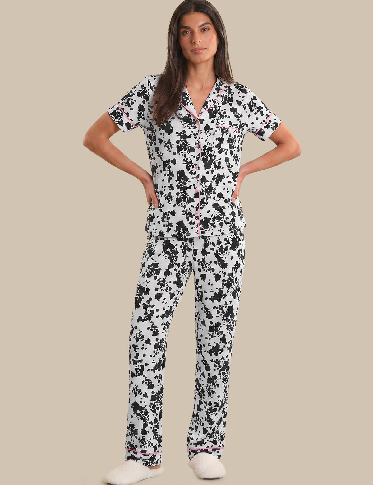 Woman wearing a black and white floral pajama set on a beige background