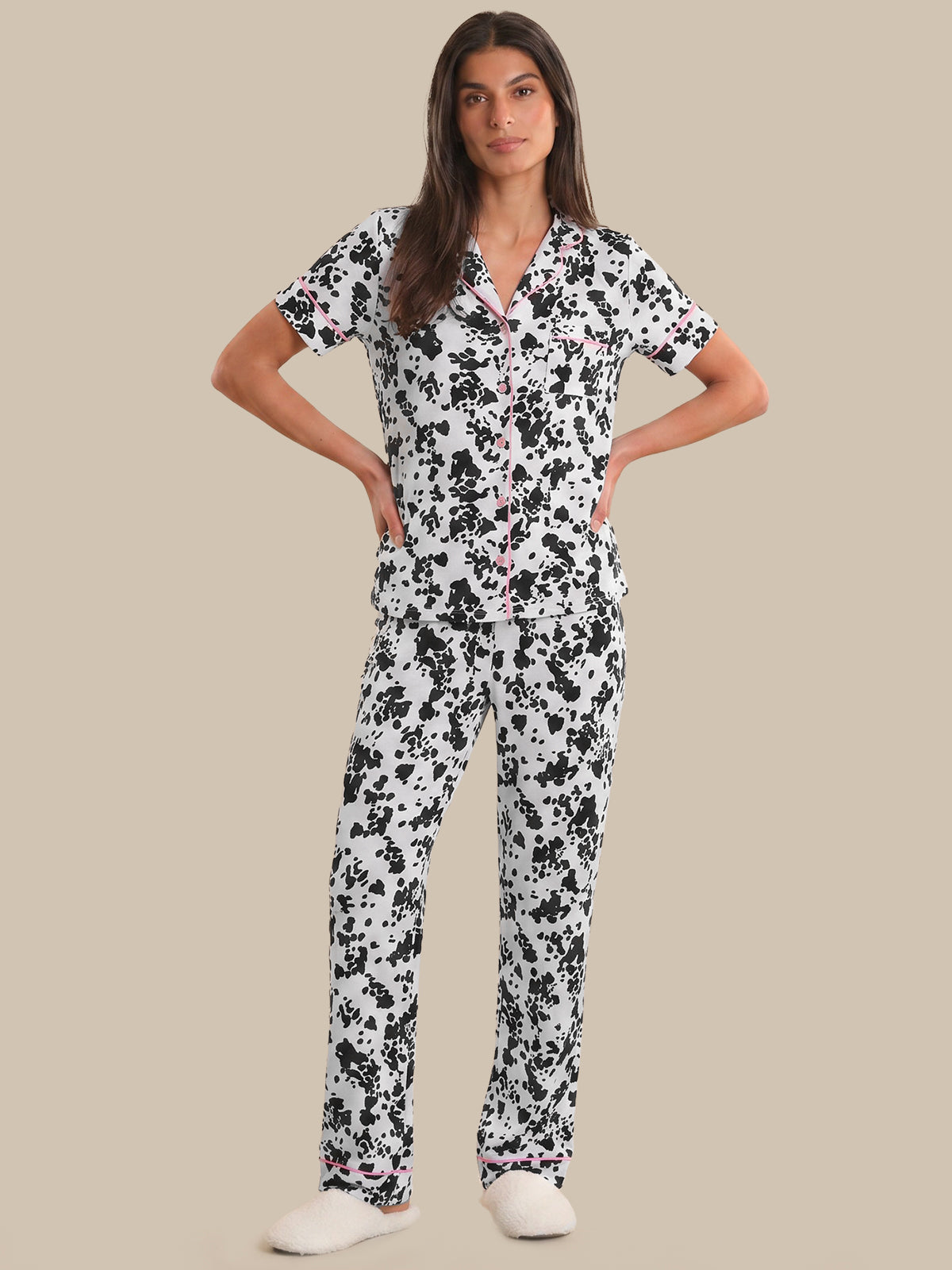 Woman wearing a black and white floral pajama set on a beige background