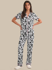 Woman wearing a black and white floral pajama set on a beige background