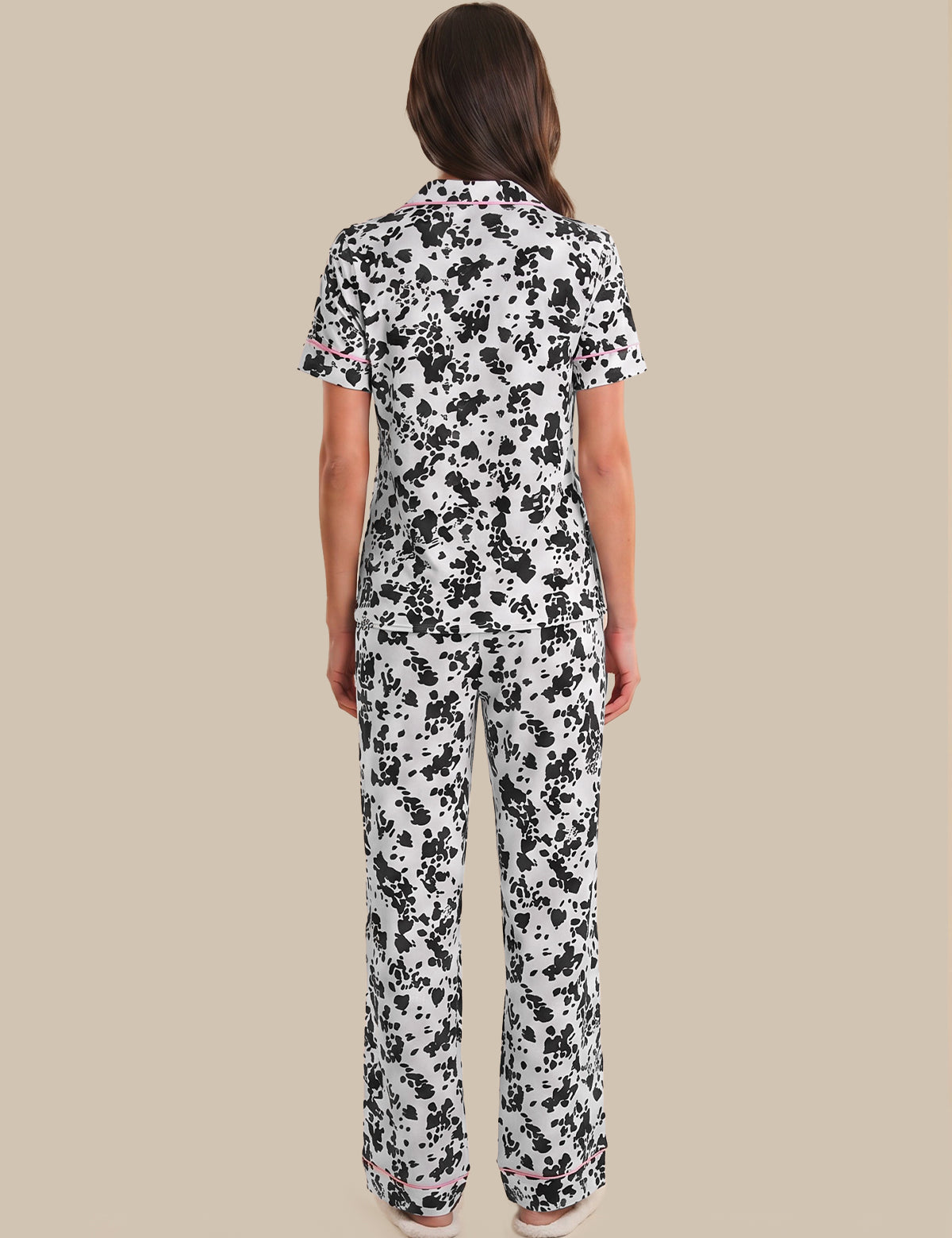 Person wearing a black and white floral pajama set on a beige background