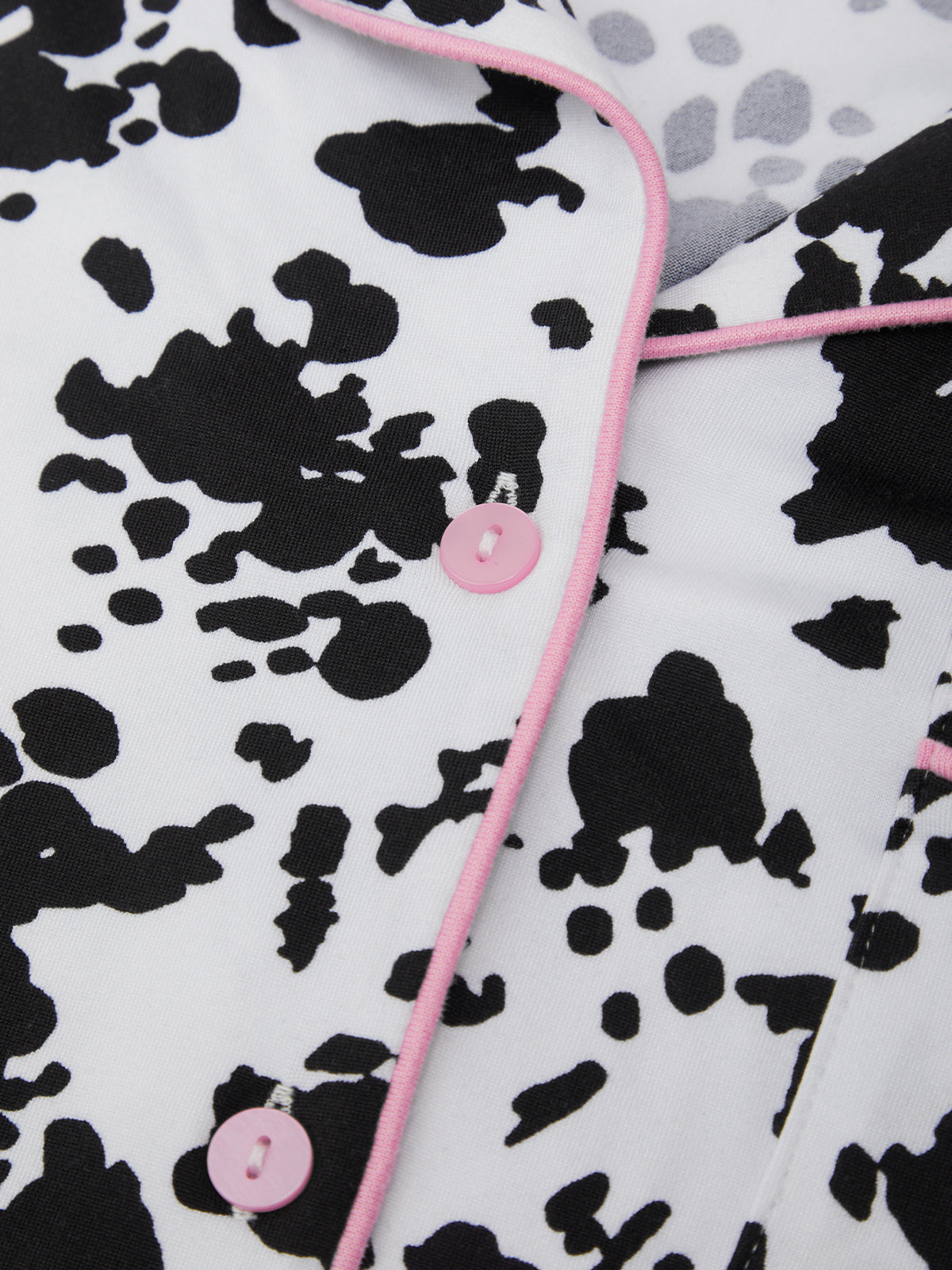Cow print fabric with pink buttons and trim