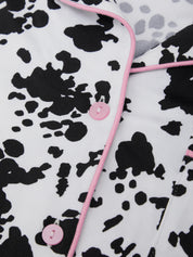 Cow print fabric with pink buttons and trim