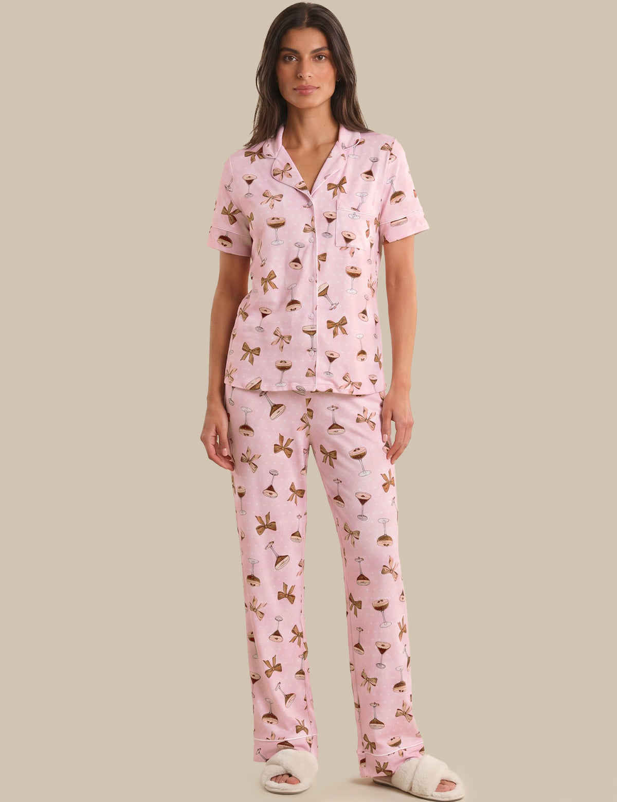 Woman wearing a pink pajama set with a pattern on a beige background