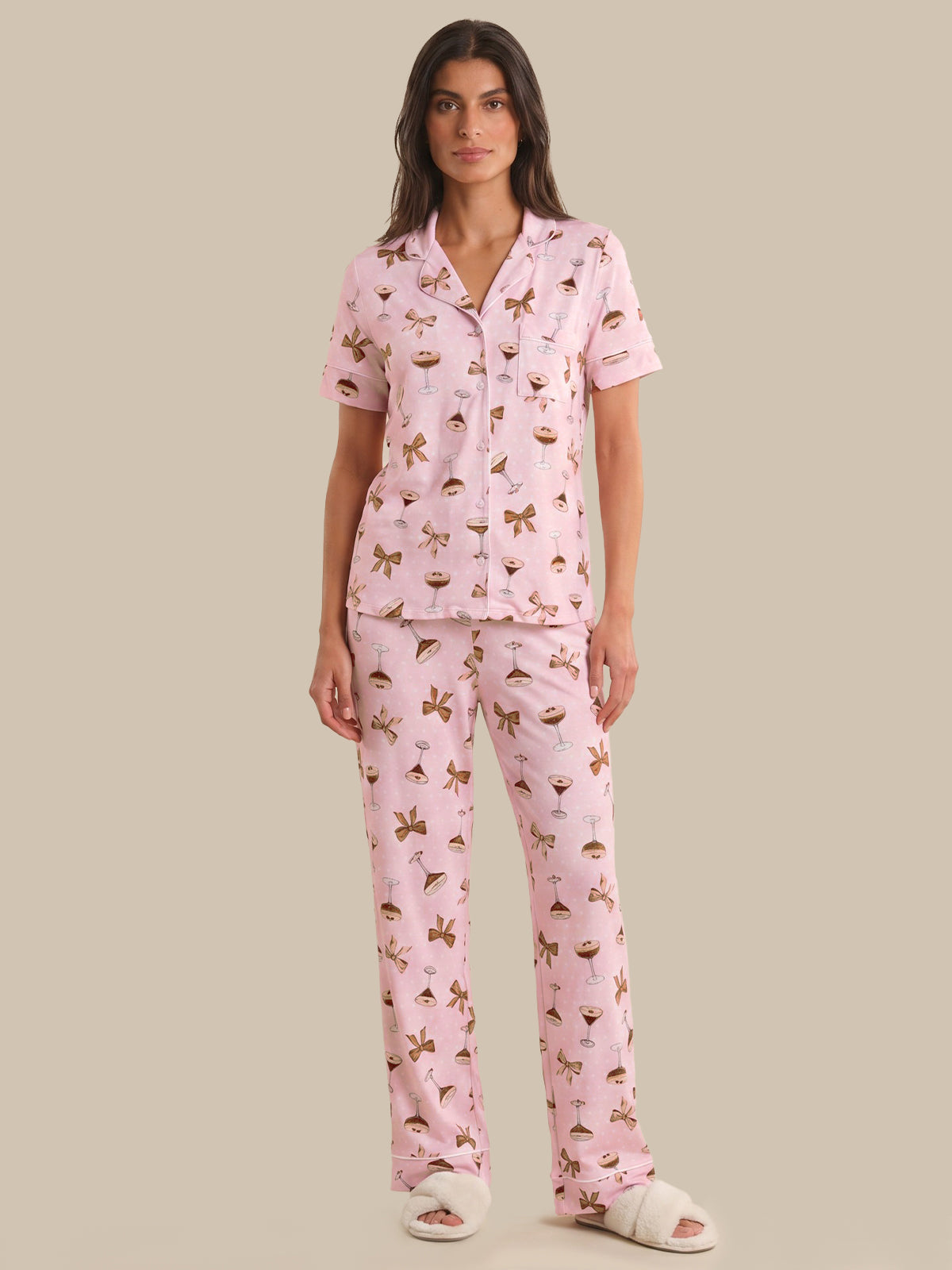 Woman wearing a pink pajama set with a pattern on a beige background