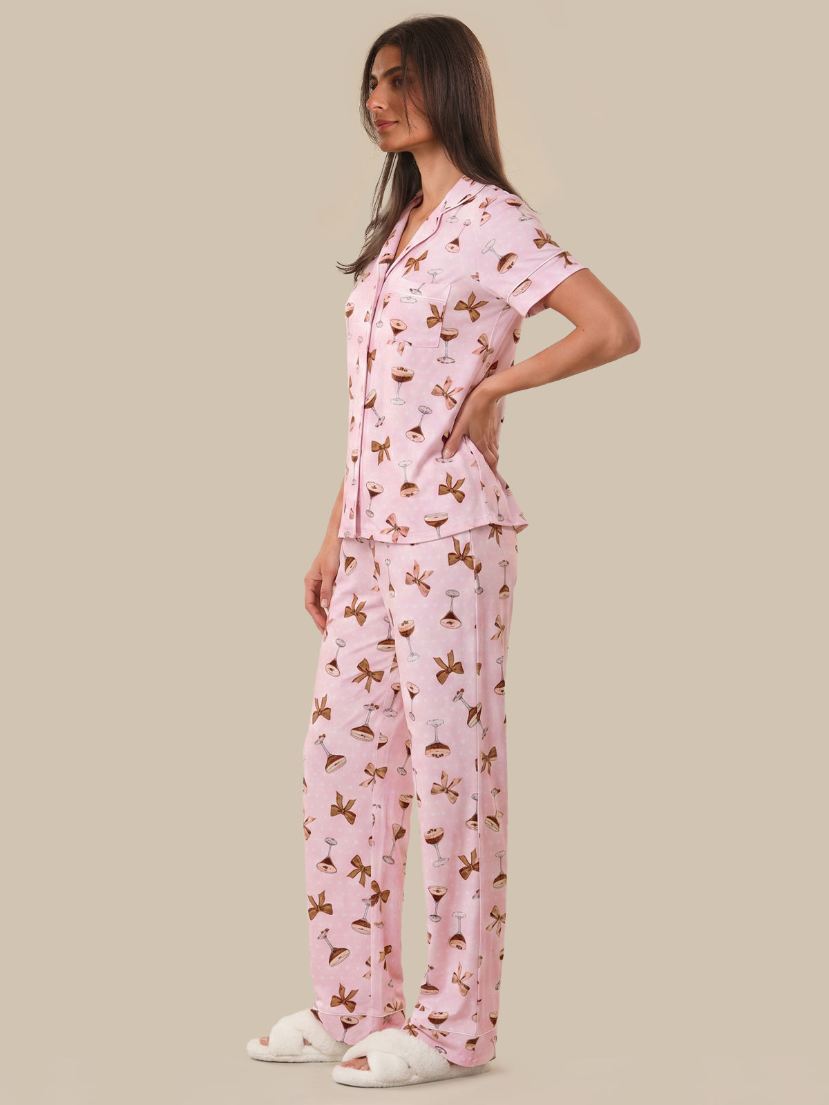 Woman wearing a pink pajama set with a pattern on a beige background